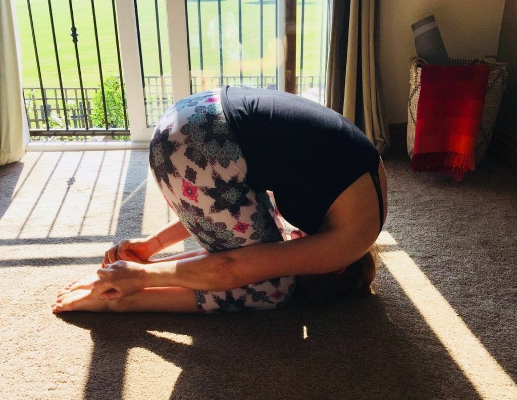 a woman sitting on the floor in front of a sliding glass door.