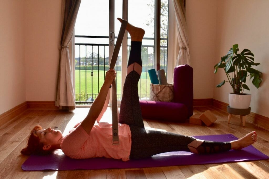 a woman doing a yoga pose on a mat.