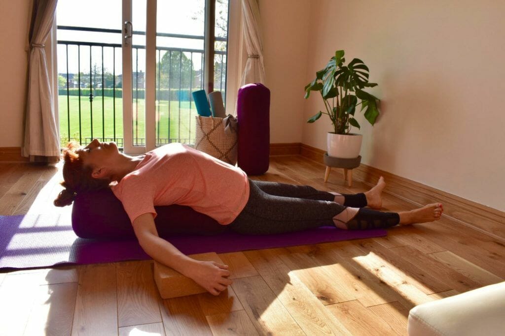 a woman laying on a yoga mat in a living room.