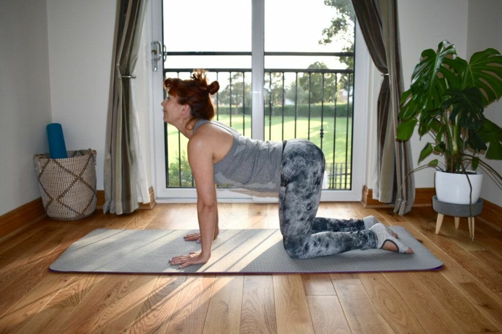 a woman is doing a yoga pose on a mat.