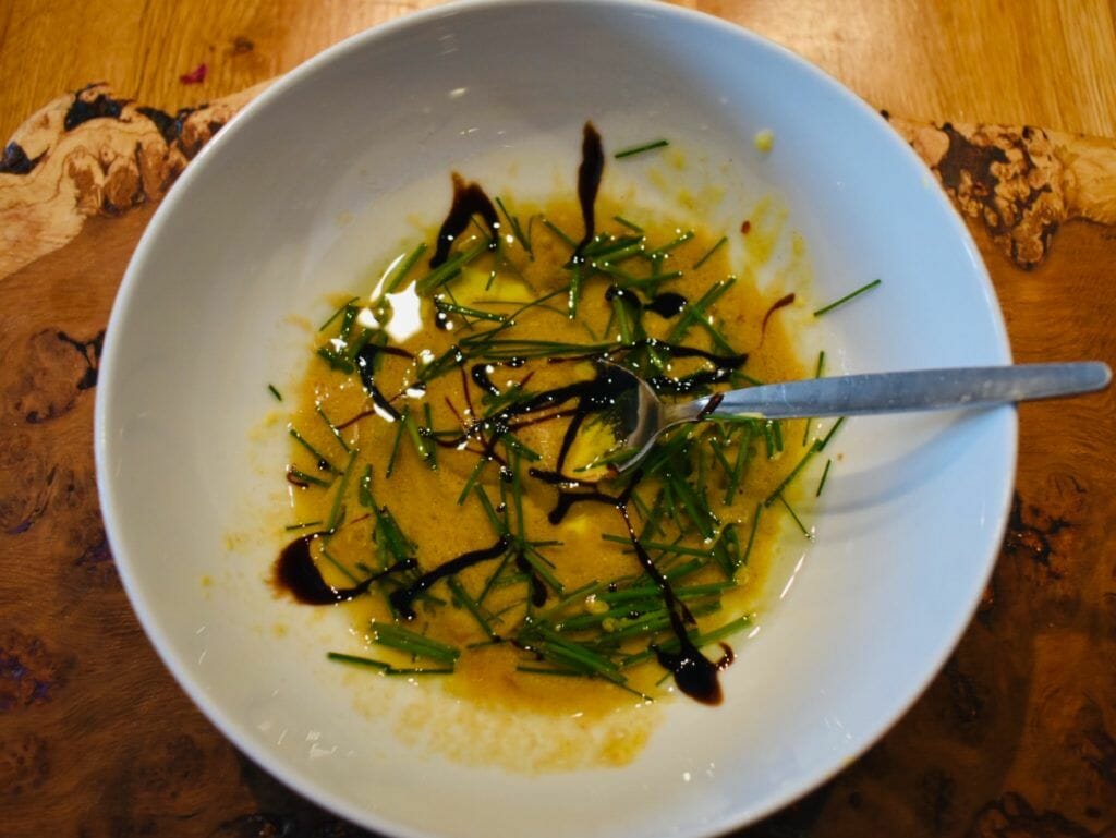 a white bowl filled with food on top of a wooden table.