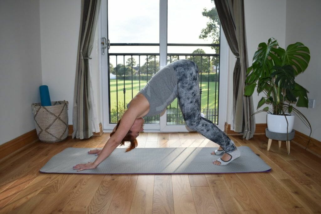 a woman doing a handstand on a yoga mat.