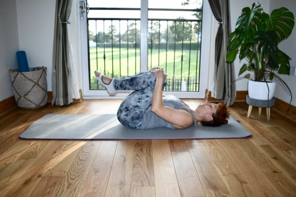 a woman is doing a yoga pose on a mat.