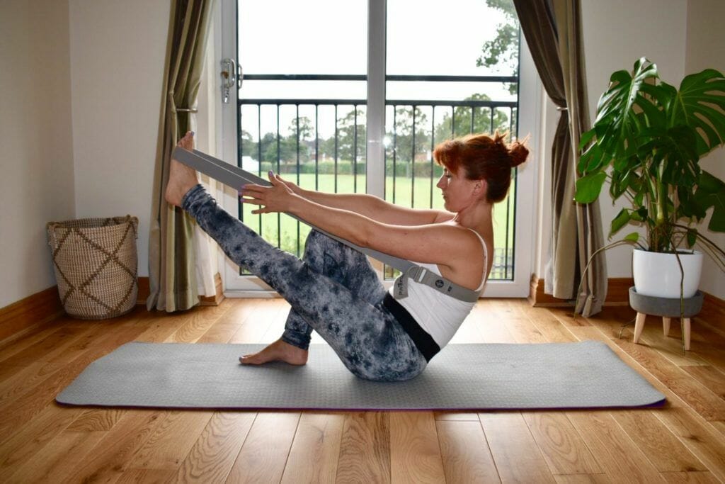 a woman is doing a yoga pose on a mat.