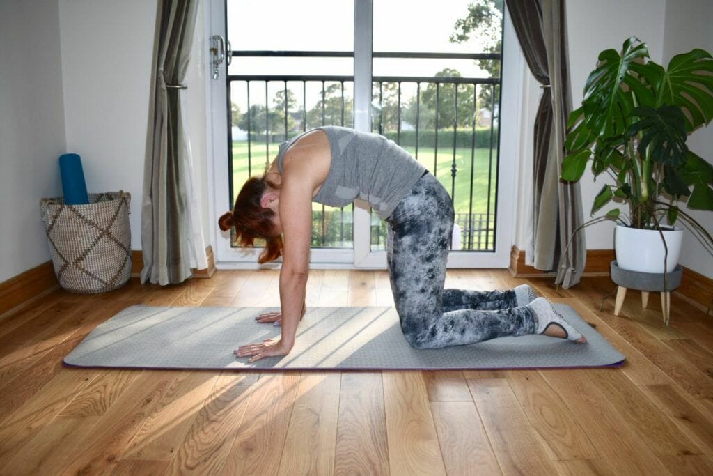 a woman is doing a yoga pose on a mat.