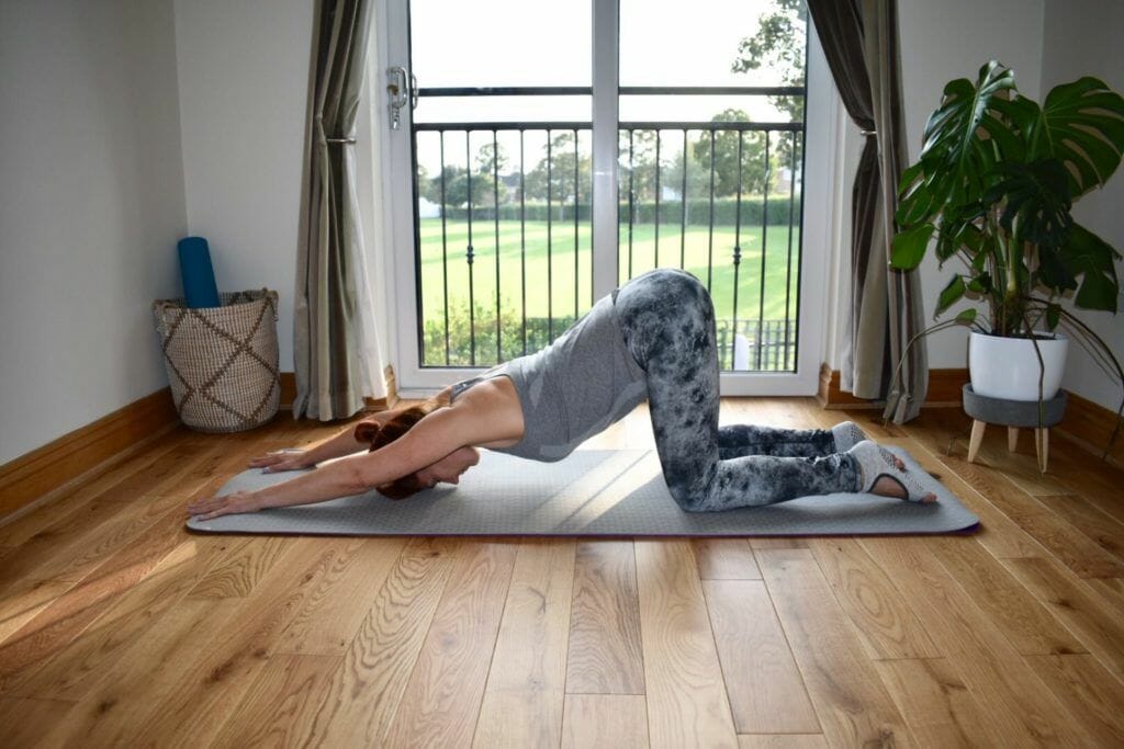 a woman is doing a yoga pose on a mat.