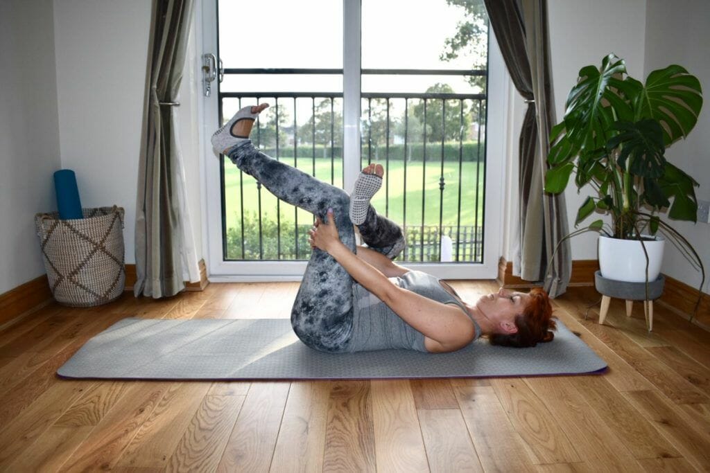 a woman is doing a yoga pose on a mat.