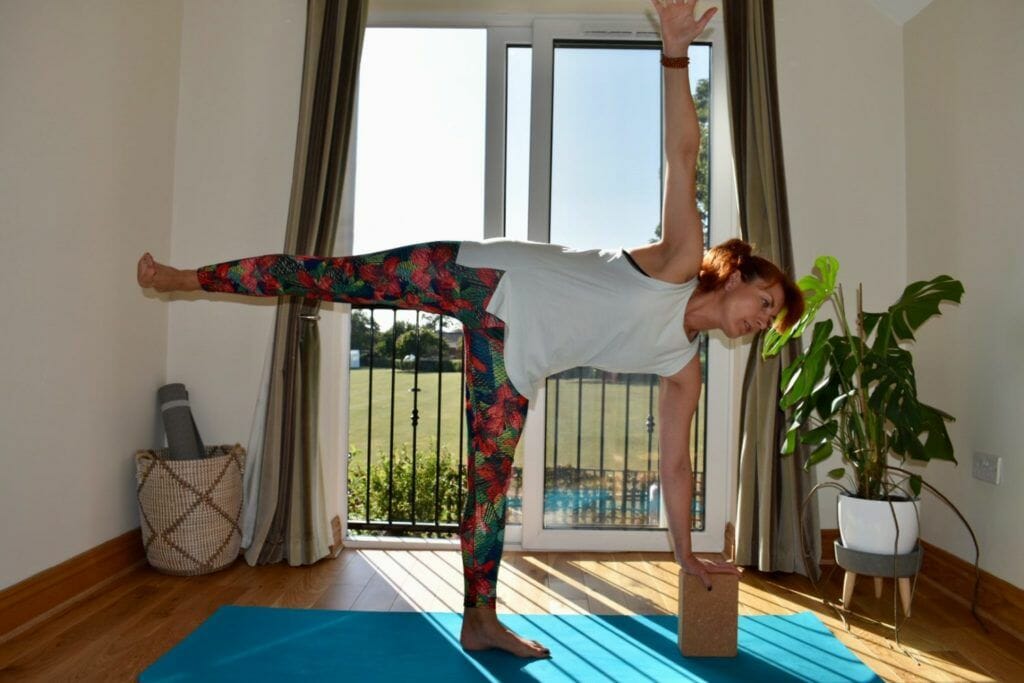 a woman doing a yoga pose on a yoga mat.