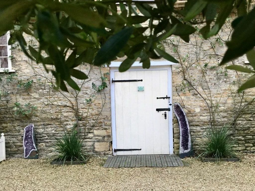 a white door sitting in front of a stone building.