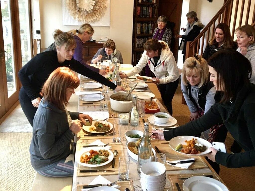 a group of people sitting around a table eating food.