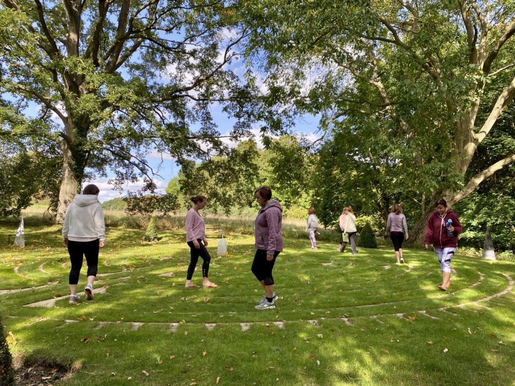a group of people standing on top of a lush green field.