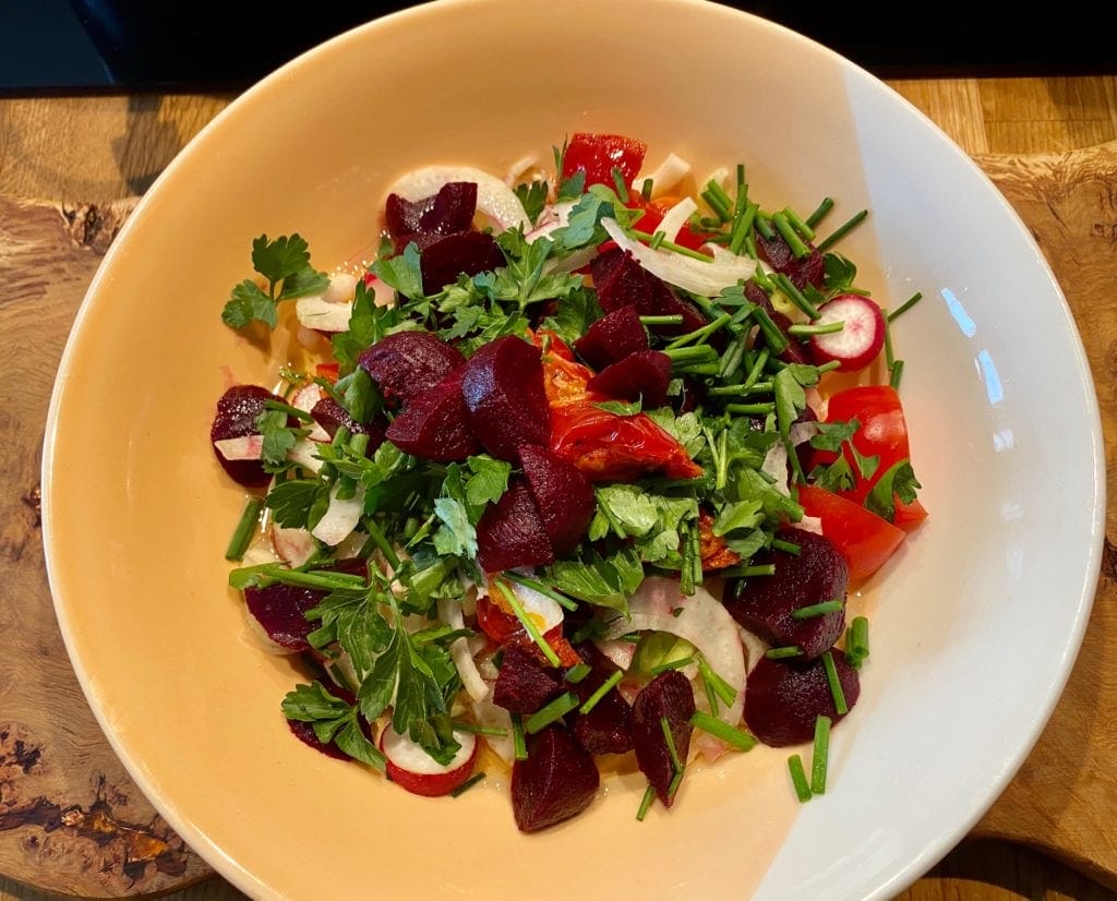 a plate of food that includes beets, onions, and parsley.