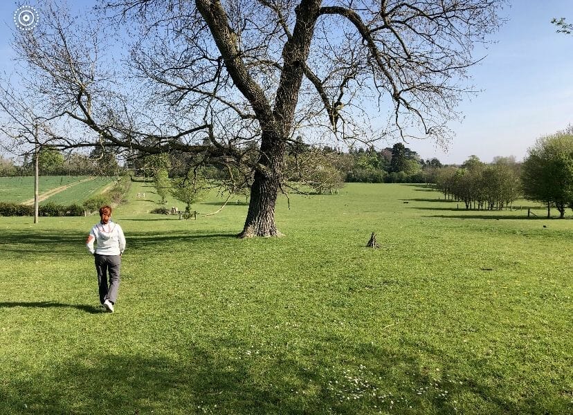 a woman is running in a grassy field.