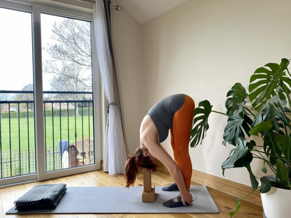 a woman doing a yoga pose on a yoga mat.