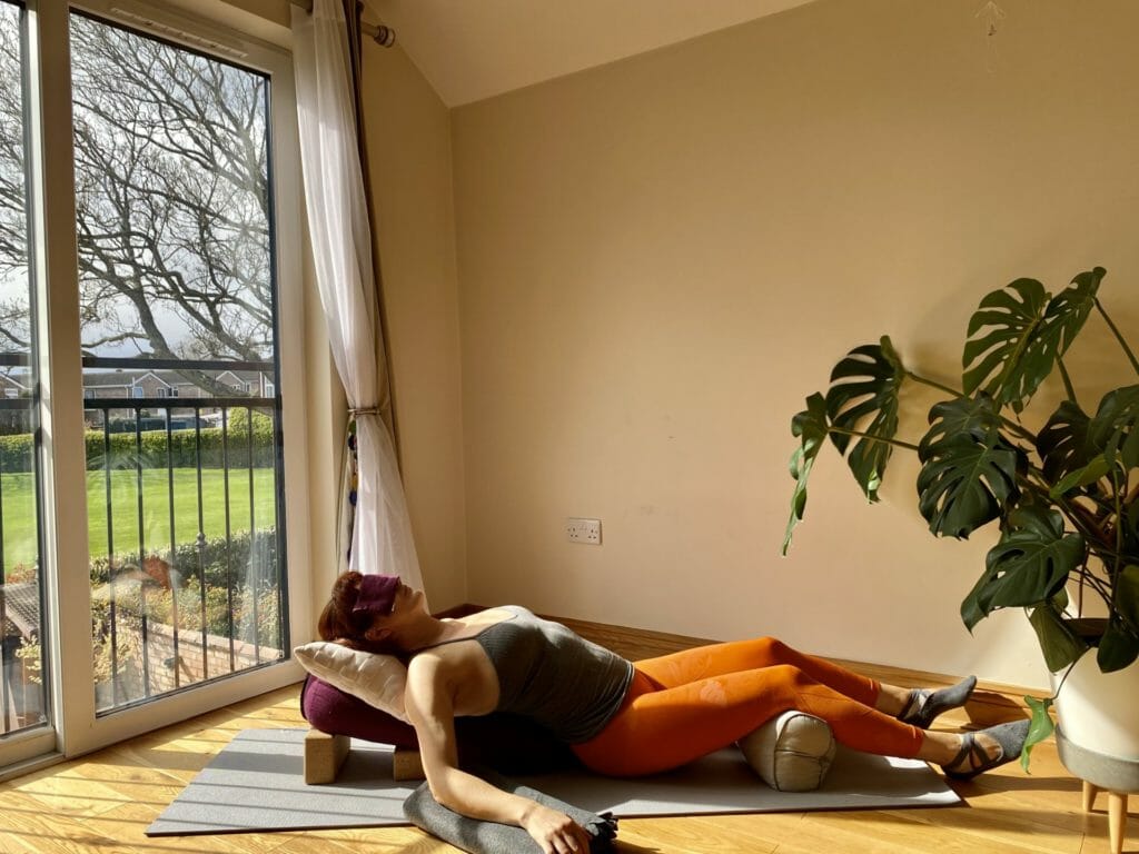 a woman laying on a yoga mat in front of a window.