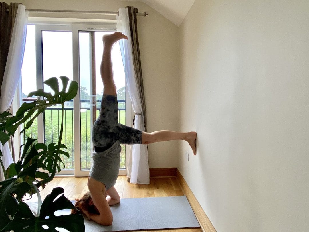 a person doing a handstand on a yoga mat.