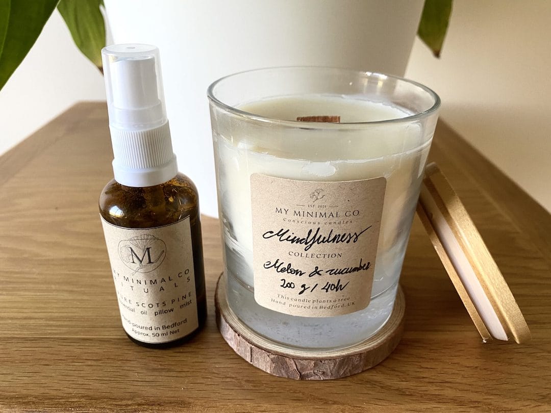 a bottle of essential oil next to a candle.