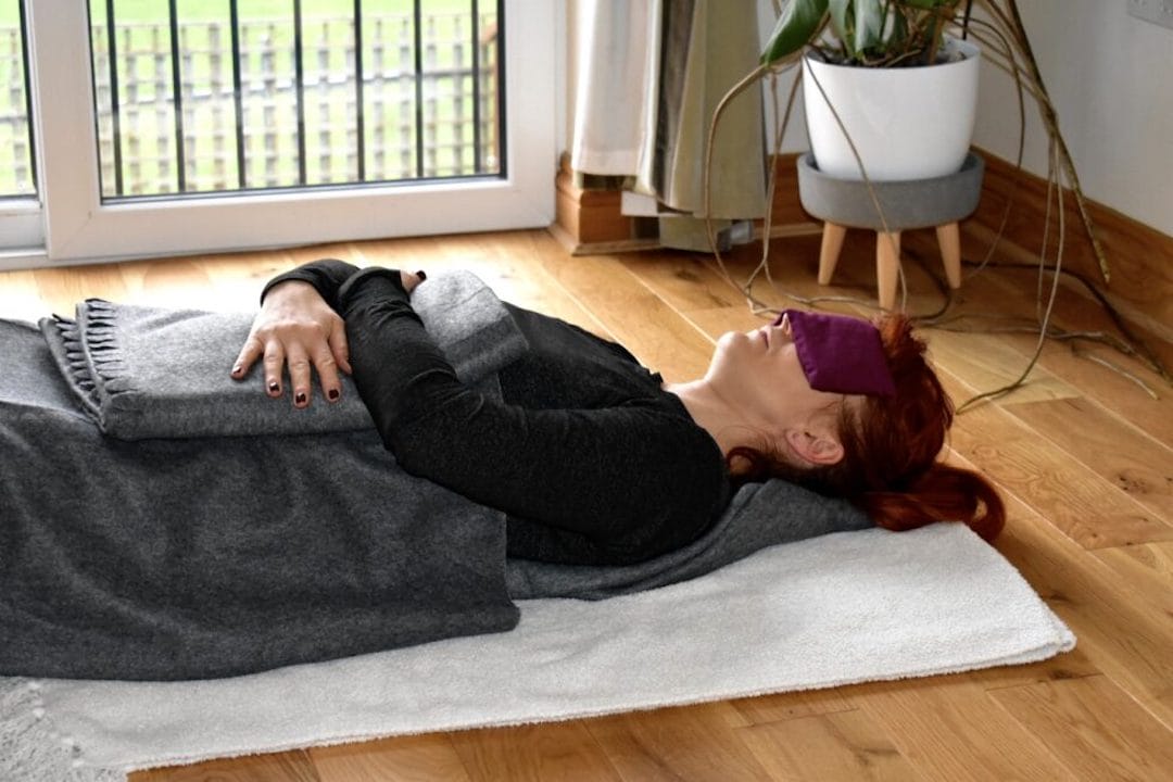 a woman laying on the floor with her eyes closed.