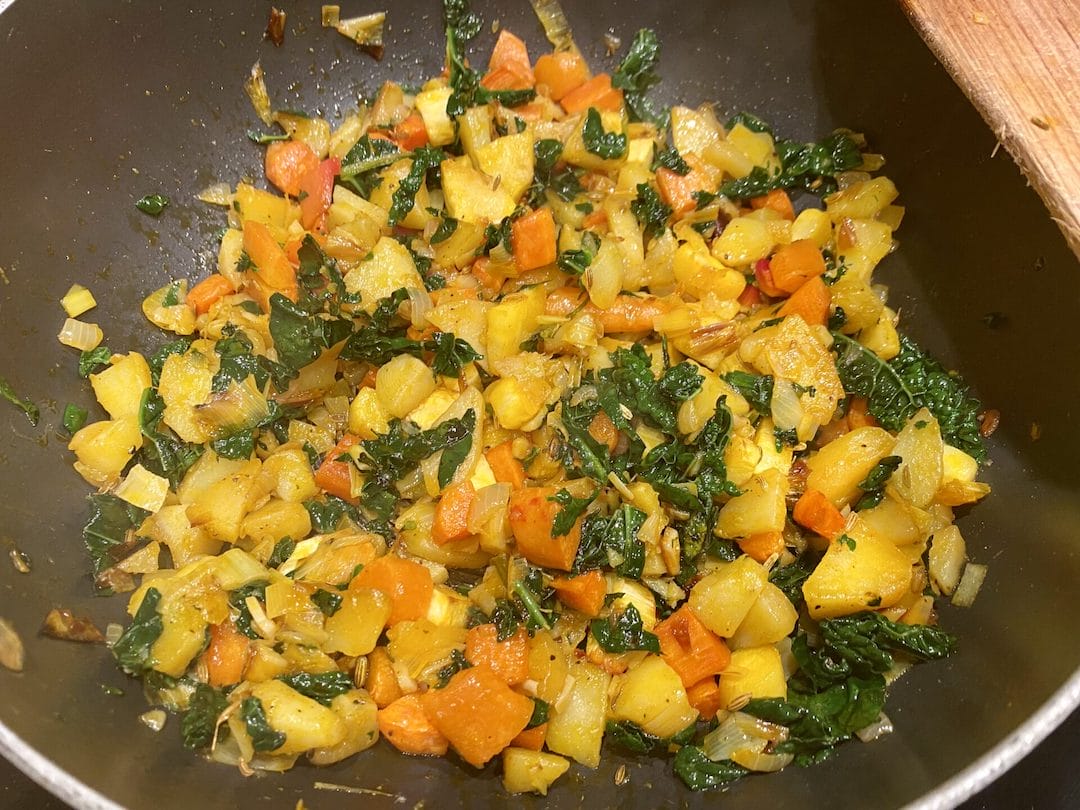 a pan filled with vegetables on top of a stove.