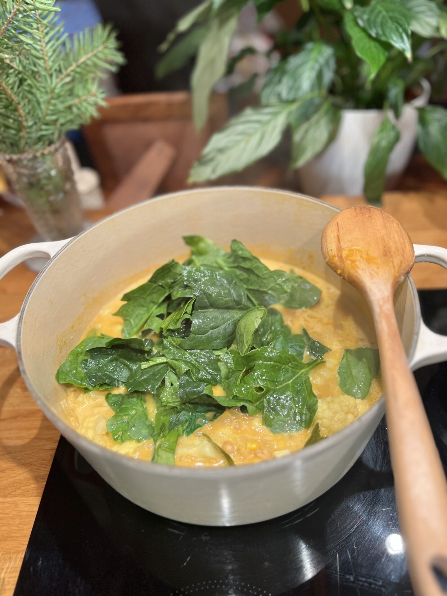 a pot of food on a stove with a wooden spoon.