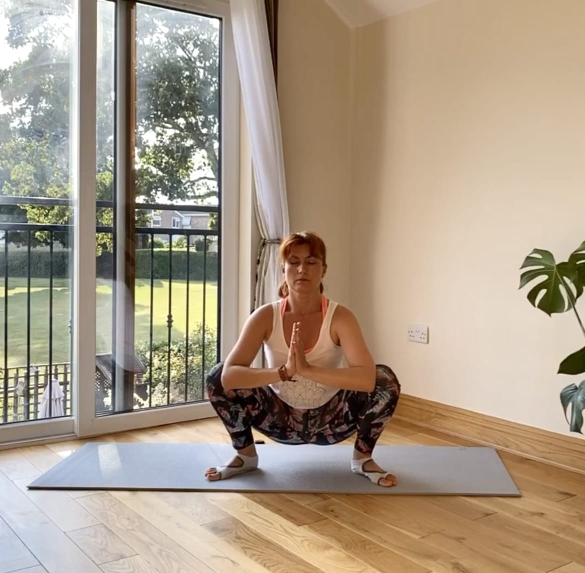 a woman in a yoga pose in front of a window.