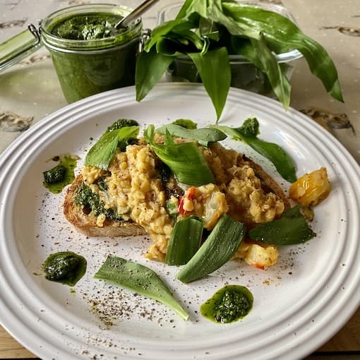 a white plate topped with a piece of bread covered in veggies. a white plate topped with a piece of bread covered in veggies.