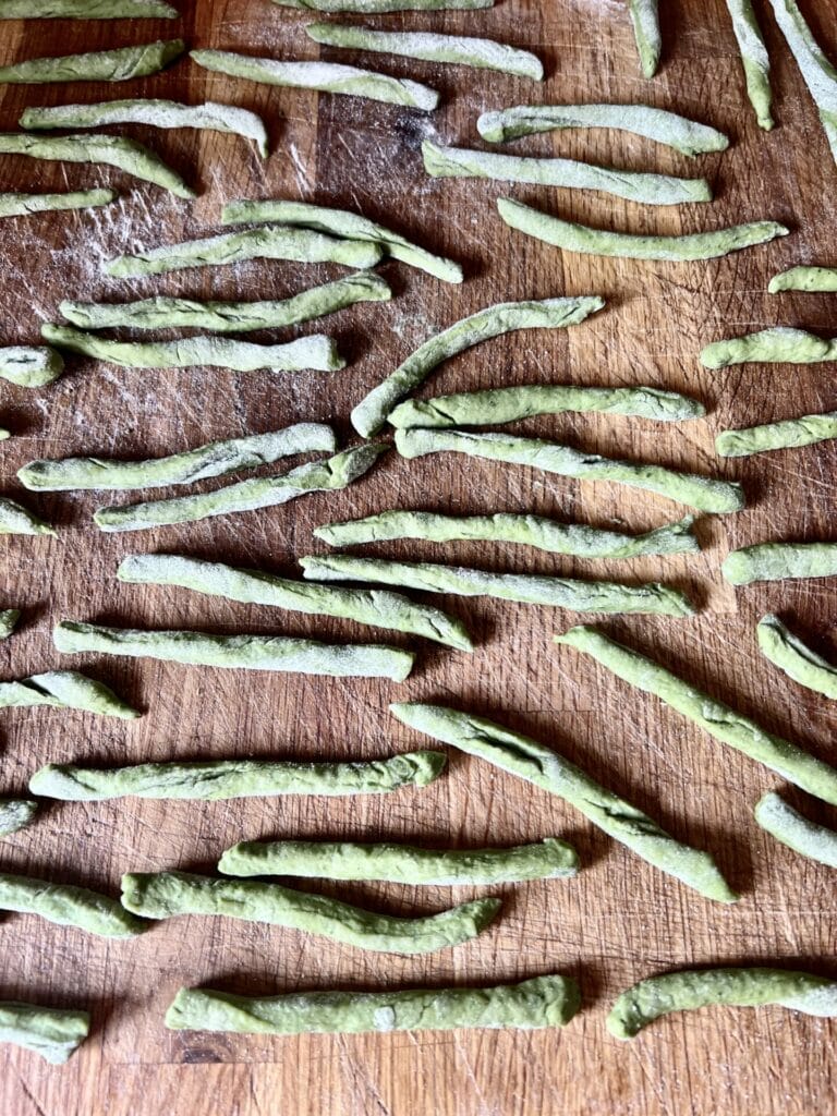 Green bean sticks on a cutting board.