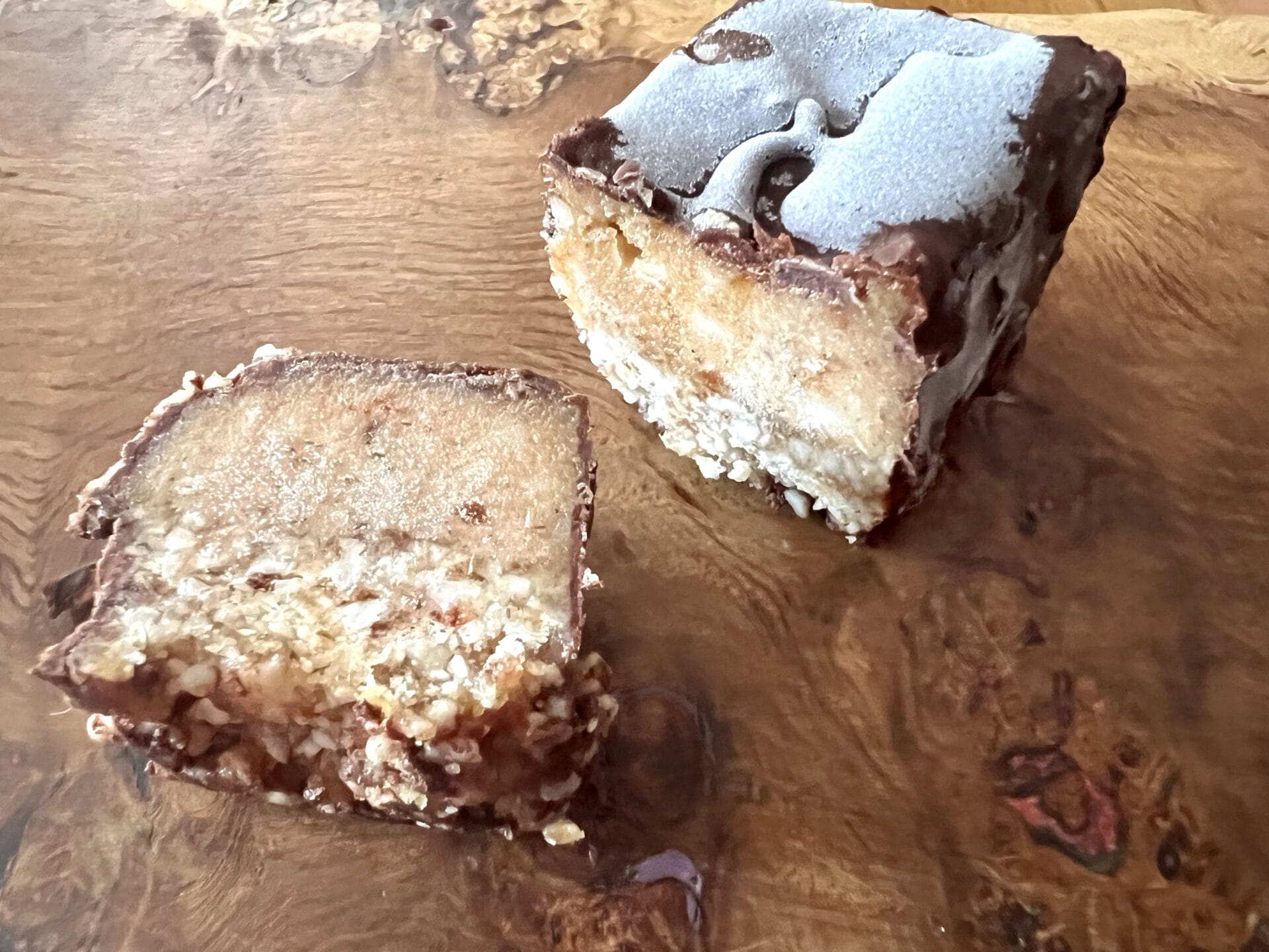 A piece of chocolate fudge sitting on top of a wooden cutting board.
