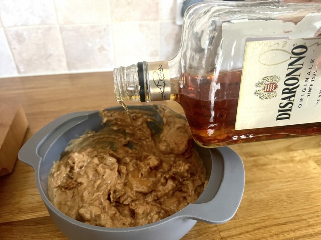A bottle of Disaronno is being poured into a bowl.