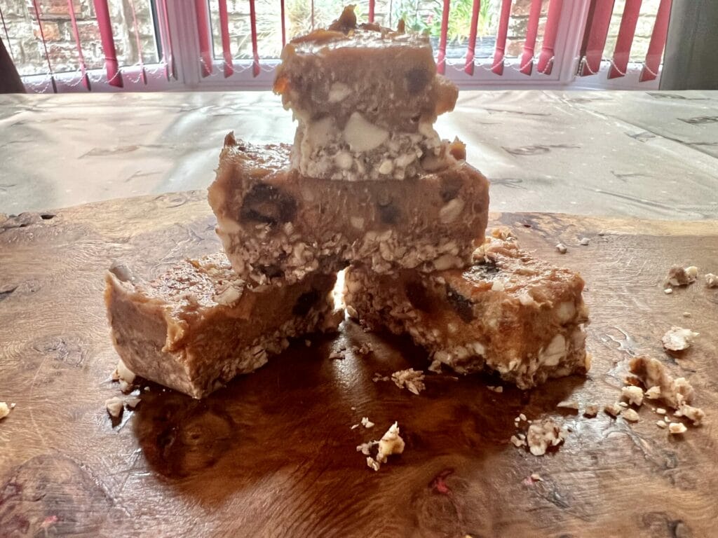 A stack of peanut butter fudge bars on a wooden cutting board.