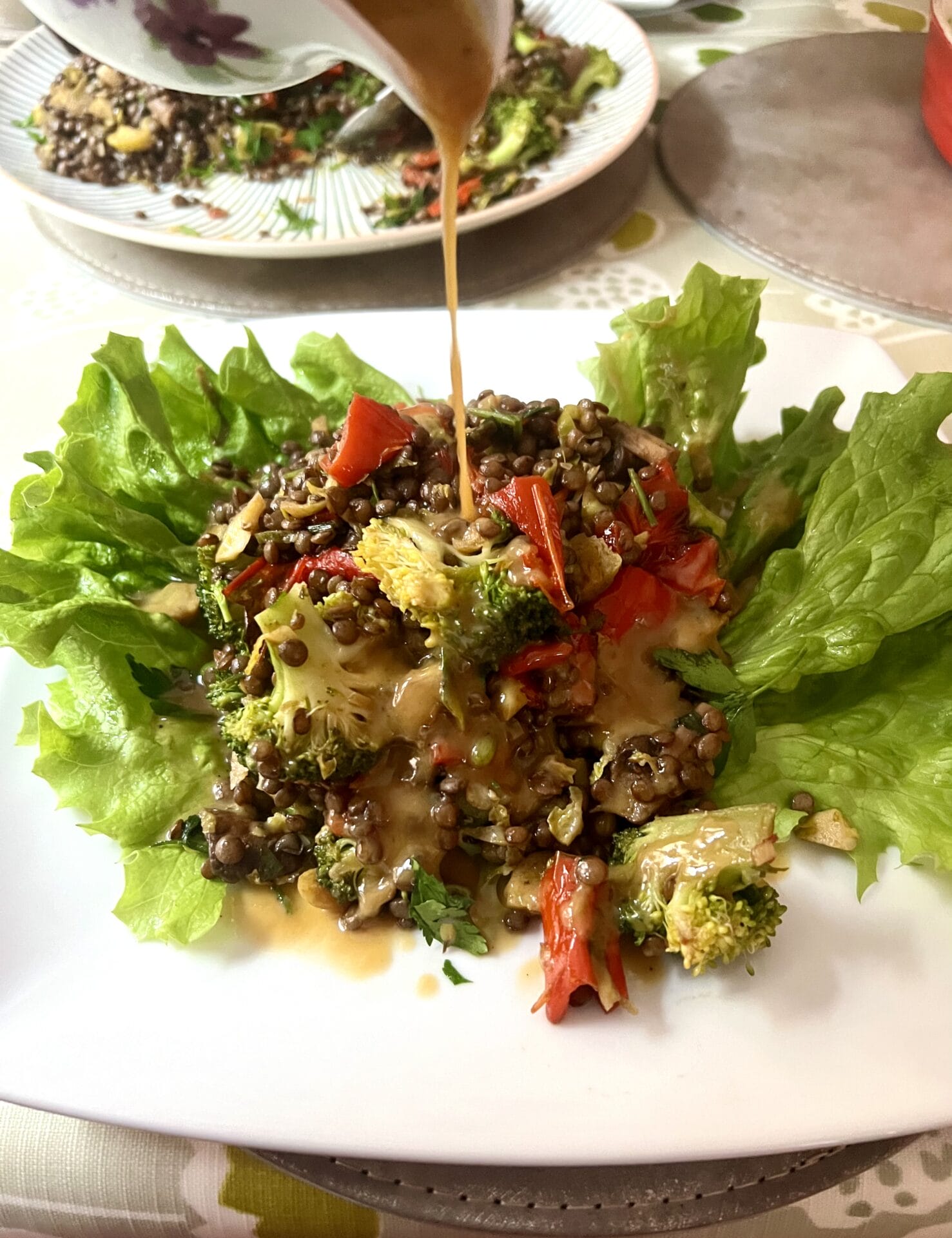 A plate of lettuce with a sauce being poured over it.