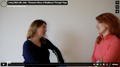 Two women sitting and smiling at each other during an interview against a plain background.